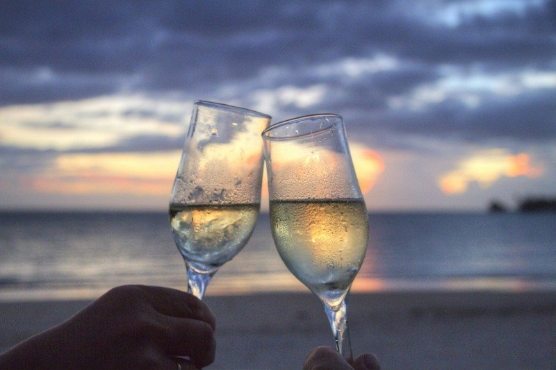 friends-toasting-with-champagne-flute-on-beach-at-sunset.jpg